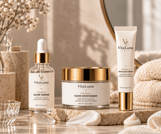 Eye cream skincare set with ivory and gold packaging, featuring a squeeze tube, glass serum bottle, and moisturizer jar