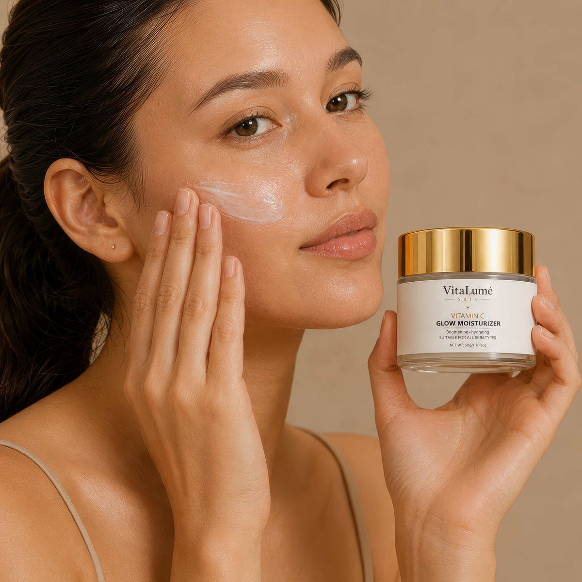 Face Moisturizer in a clear jar with a gold lid, shown beside a woman applying the cream to her cheek